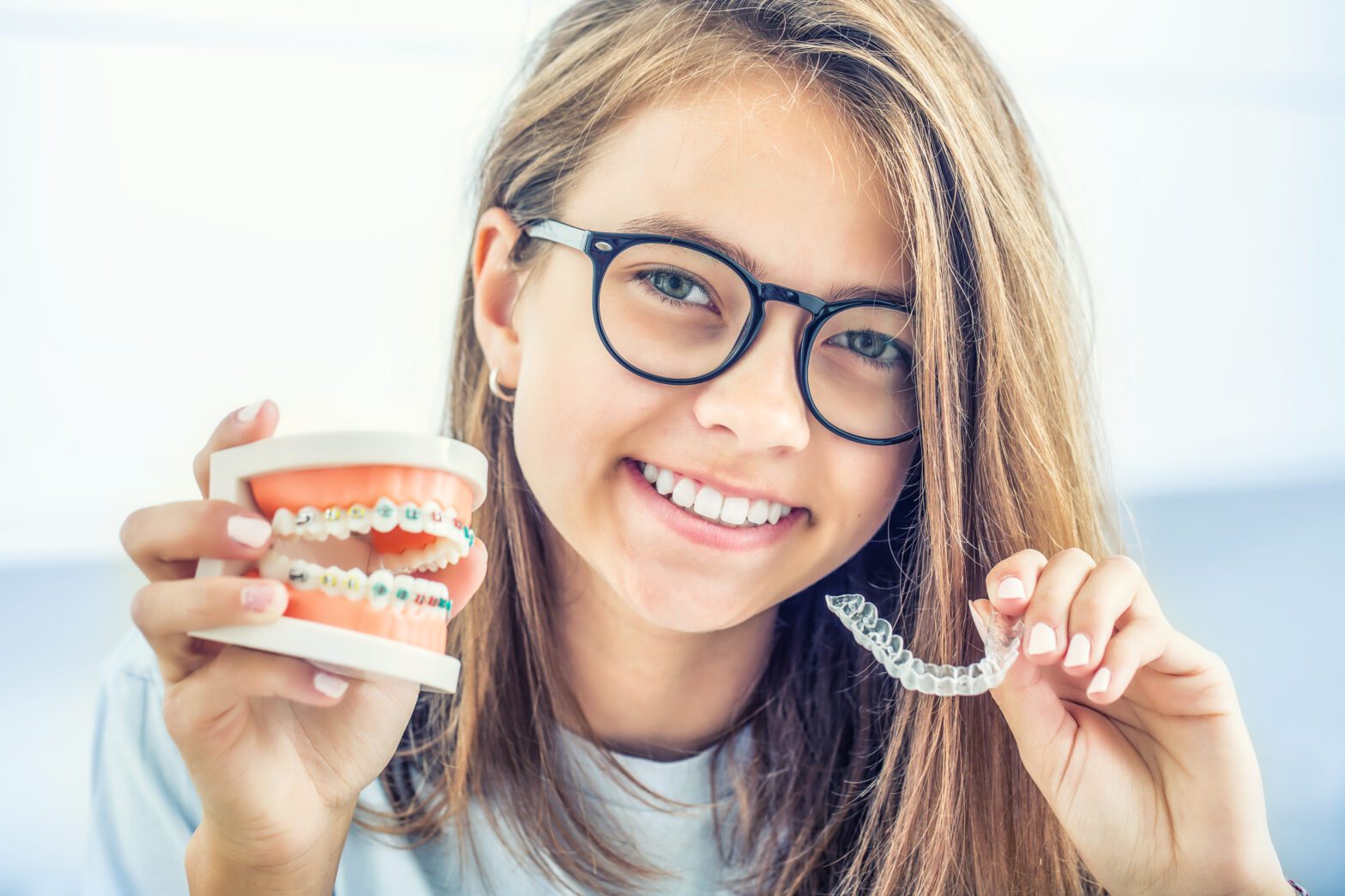 Braces vs Aligners? A young girl showing the difference
